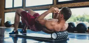 Athlete performing foam rolling exercise for muscle recovery