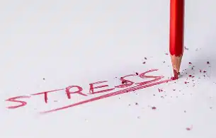 Mot stress écrit en rouge avec un crayon cassé, symbolisant la pression mentale